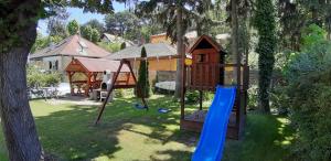 un parque infantil en un patio con un árbol en Holiday house Riviera - Balaton - Siófok, en Siófok