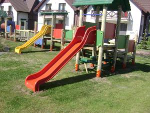un parque infantil con un tobogán en el césped en Apartament Blue eye, en Żarnowska