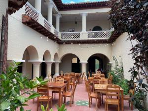 a patio with wooden tables and chairs in a building at Ricks hostel Santa Ana in Santa Ana