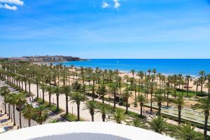 uma vista para uma praia com palmeiras e para o oceano em Acacias Suites Apartments Salou em Salou