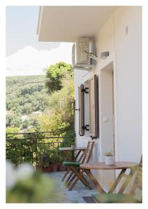 a balcony with two wooden chairs and a table at Le Quartier Comfy Studios in Parga