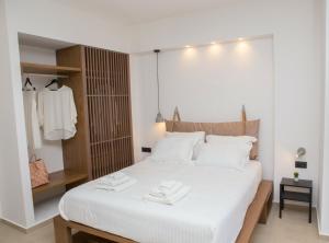 a bedroom with a large white bed with white sheets at Le Quartier Comfy Studios in Parga