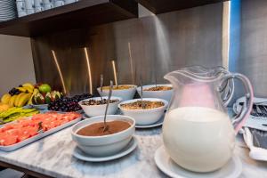 a counter with bowls of food and a pitcher of milk at Hotel Bys Palermo in Buenos Aires