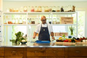 a man standing in a kitchen preparing food at La Foresteria Planeta Wine Resort & Beach Club in Menfi