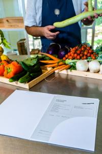 a person standing next to a table with fruits and vegetables at La Foresteria Planeta Wine Resort & Beach Club in Menfi