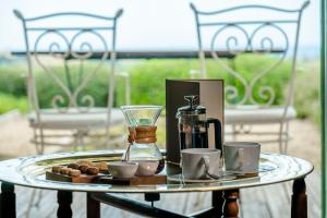 a tray with a coffee maker and cups on a table at La Foresteria Planeta Wine Resort & Beach Club in Menfi