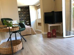uma sala de estar com uma televisão de ecrã plano e cadeiras em Maravilloso Guesthouse em Fuengirola