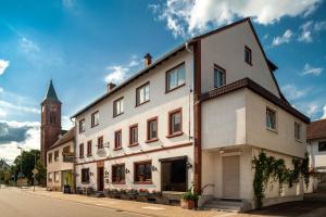 Hotel & Restaurant Raisch في Steinwenden: مبنى على شارع فيه برج ساعه