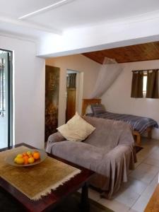 una sala de estar con sofá y un bol de naranjas sobre una mesa en 31 on Kloof, en Aurora