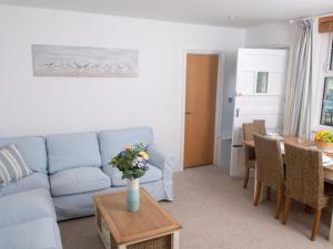 een woonkamer met een blauwe bank en een tafel bij Harbour Retreat Trinity Mews in Torquay