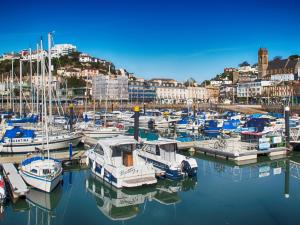 een stel boten aangemeerd in een jachthaven met een stad bij Harbour Retreat Trinity Mews in Torquay