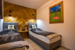 a bedroom with two beds and a painting on the wall at Apartament Muszyna in Muszyna