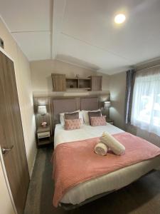 Lakeshore Lodge with Hot Tub في بوكلينجتون: غرفة نوم بسرير كبير مع بطانية وردية