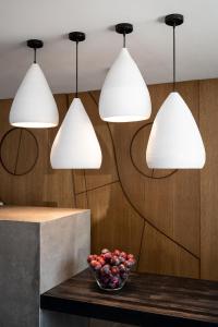 Stella Luxury Apartments في أغيا غاليني: ثلاثة أضواء معلقة فوق طاولة مع وعاء من الفواكه
