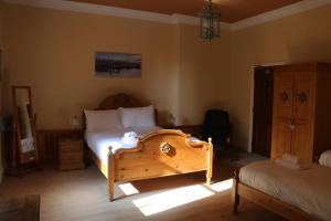 um quarto com uma cama e uma cómoda num quarto em Cae'r Blaidd Country House em Ffestiniog