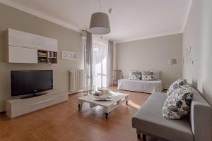 een woonkamer met een bank en een tv bij Natural chic - Close to city center and beach - parking in Desenzano del Garda