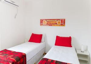 two beds in a room with red pillows at Pousada Maiken in Florianópolis