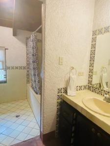 a bathroom with a shower and a sink and a tub at Antigua Guatemala Villas in Antigua Guatemala