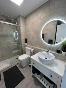 Copacabana ocean view apartament في بلايا فانياب: حمام مع حوض ومرحاض ومرآة