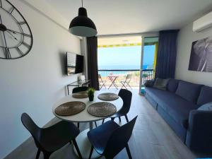 sala de estar con mesa, sillas y sofá en Copacabana ocean view apartament, en Playa Fañabe