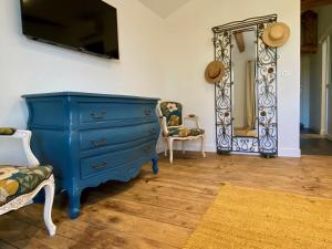 niebieska komoda i lustro w pokoju w obiekcie Aux Rives de la Courtade w mieście Rivières
