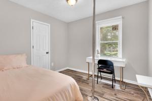 1 dormitorio con cama, escritorio y silla en Pleasant Stay Getaway, en Atlanta