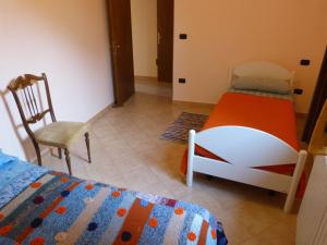 a bedroom with two twin beds and a chair at IL Casale del Galantuomo in Castelsaraceno