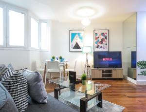 ein Wohnzimmer mit einem Sofa und einem TV in der Unterkunft Tudors eSuites Five Ways Two Bedroom Apartment in Birmingham