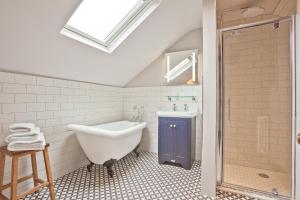 a bathroom with a tub and a sink and a shower at Bumble Choo Cottage - Windermere, Lake District in Windermere