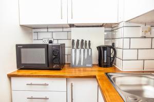 a kitchen counter with a microwave and a sink at SUMMIT Apartment - Cozy Aberdeen West End Flat Prime Location - Perfect for Short or Long stay - 1 bedroom in Aberdeen