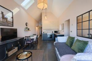 a living room with a couch and a tv at Coach House Cottage on the shores of Lough Corrib in Galway