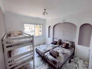 sypialnia z 2 łóżkami i łóżkiem piętrowym w obiekcie La Villa Castel - Haut de villa - parkings- 3 chambres - 8 couchages - jardin - barbecue w Cagnes-sur-Mer
