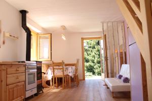 a kitchen with a table and a dining room at Chalet Baita delle Favole di RosaRita in Berbenno di Valtellina