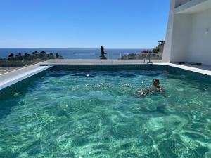 a person swimming in a swimming pool at ARABESQUE Apartments & Suite in Ulcinj