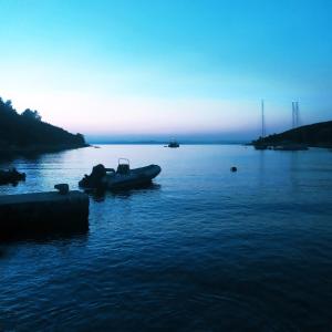 a boat in a body of water at sunset at Primitivo Bay Hvar in Hvar