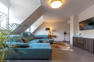 - un salon avec un canapé bleu et une table dans l'établissement Hotel Garni " Am Domplatz", à Erfurt