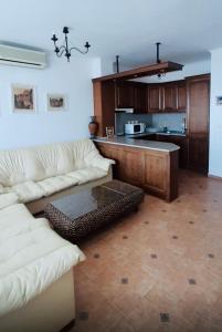 a living room with two white couches and a kitchen at Marina Dinevi Complex Monastery 1 Saint Vlas in Sveti Vlas