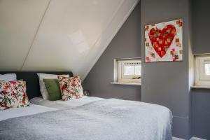 een slaapkamer met een bed en een hartschildering aan de muur bij Cottage Hazenhorst - paradijs aan het bos in IJhorst