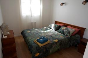 1 dormitorio con cama con colcha estampada de flores en LACADUCEE 