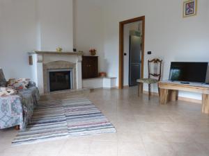 a living room with a fireplace and a television at IL Casale del Galantuomo in Castelsaraceno