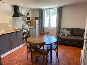 a kitchen and living room with a table and chairs at Maison St Victor in Castellane