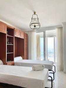 una camera con due letti e una grande finestra di Luxury family apartment in Roses a Roses