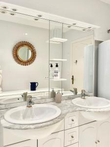un bagno bianco con due lavandini e uno specchio di Luxury family apartment in Roses a Roses