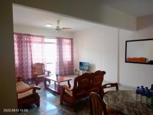 ein Wohnzimmer mit einem Tisch und Stühlen in der Unterkunft Deluxe Family Beach Condo PortDickson in Port Dickson