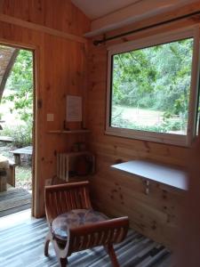 eine Blockhütte mit einer Bank und einem Fenster in der Unterkunft Echappée sauvage in Masquières