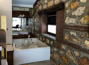 a bathroom with a bath tub in a brick wall at Masklavi in Kestel