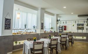 uma sala de jantar com mesas e cadeiras e uma padaria em Hotel Sandra em Rimini