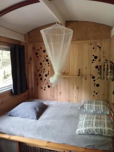ein Schlafzimmer mit einem Bett mit einem Netz an der Wand in der Unterkunft Echappée sauvage in Masquières
