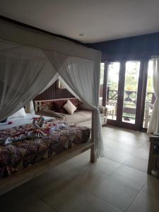 a bedroom with a bed with a canopy at BINTANG MUNDUK in Munduk