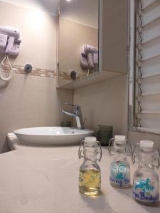 ein Badezimmer mit einem Waschbecken und zwei Glasgläsern auf einer Theke in der Unterkunft Blue lagon appart in Le Gosier